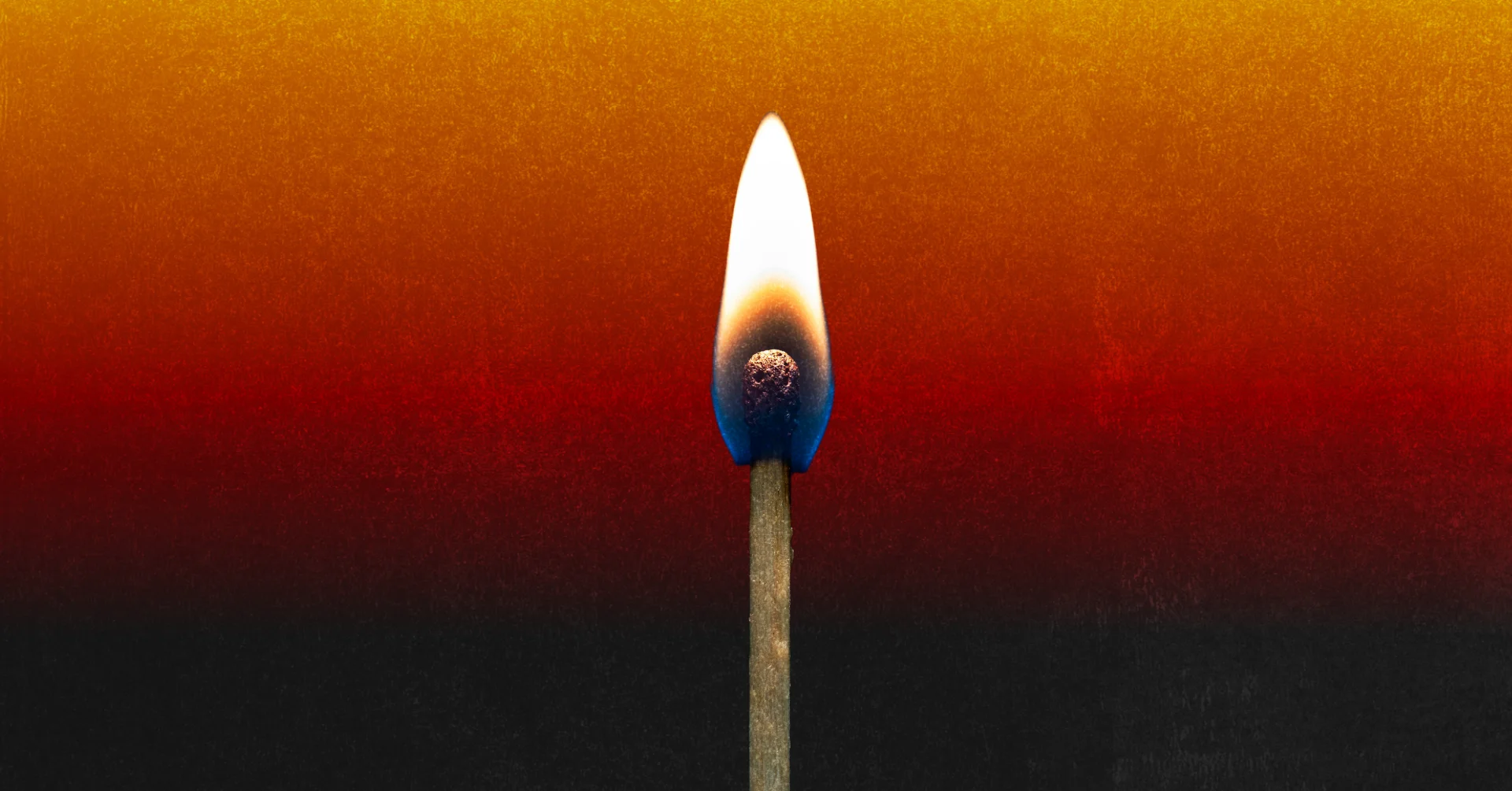 A burning match against an orange and black background